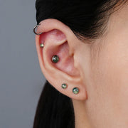 Ear arrangement featuring round green moss agate studs with silver-tone rims and a simple hoop