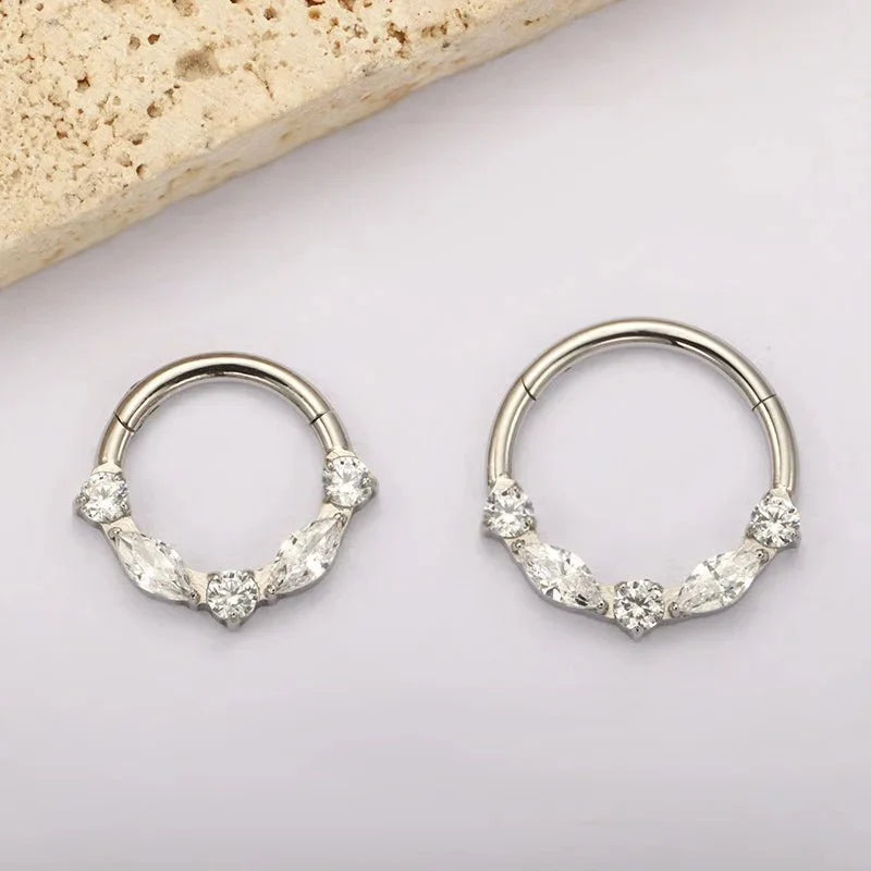 Two silver-tone marquise CZ clicker hoops with different openings on a light background