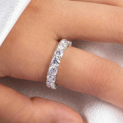 Close-up wearing photograph of a silver-tone moissanite eternity band.