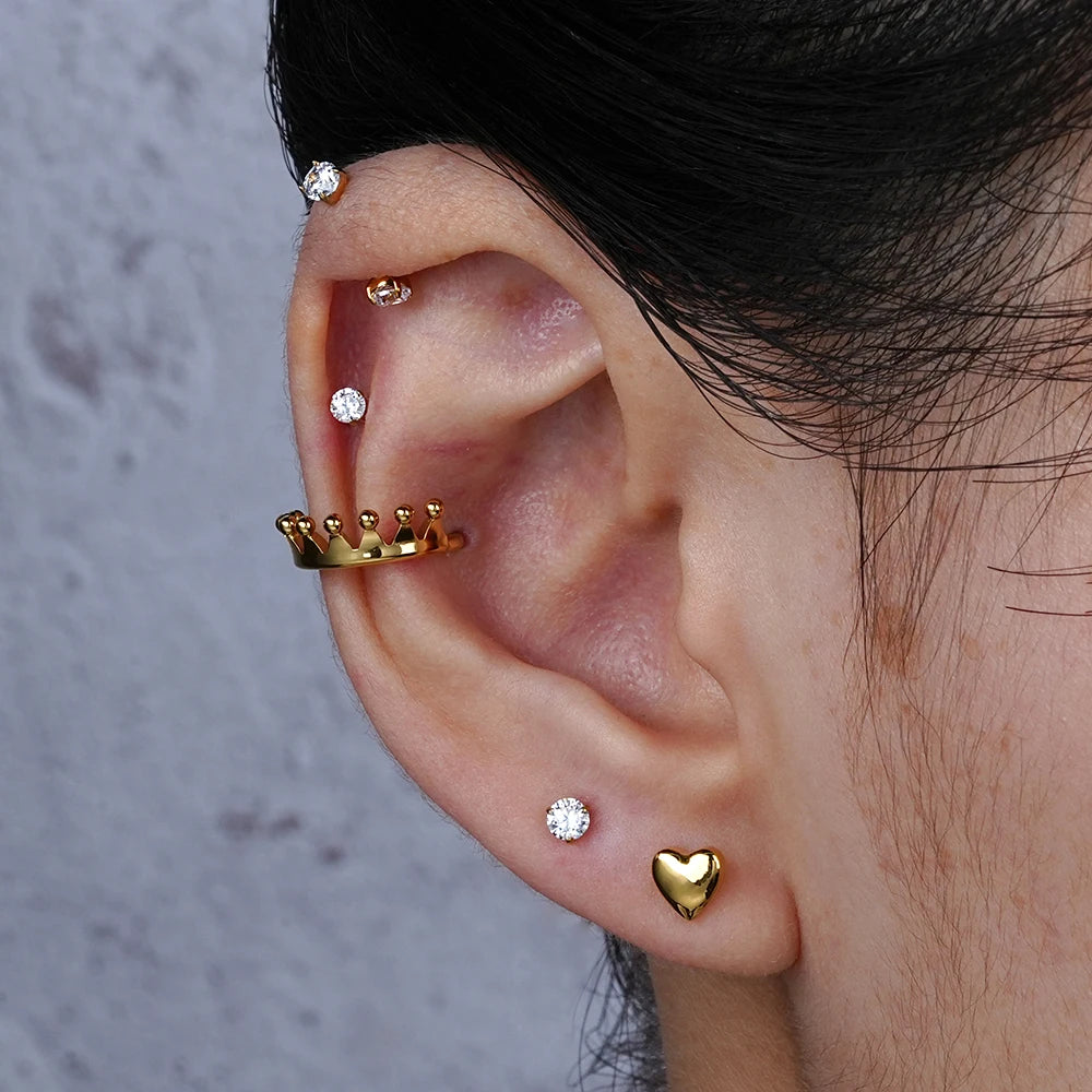 Gold titanium heart flat back stud worn in an earlobe piercing
